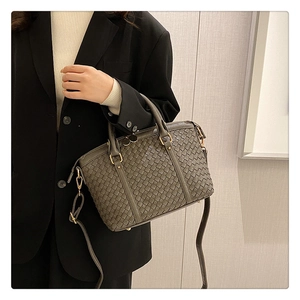 Détail du sac en cuir tressé olive foncé avec ferrures dorées et bandoulière amovible