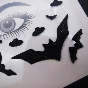 Close-up of Halloween face stickers featuring black glitter bat designs for party makeup