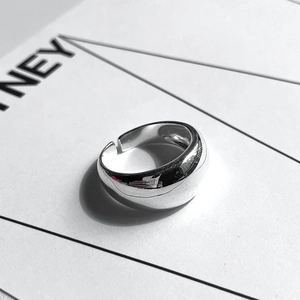Detailed view of minimalist wide sterling silver adjustable ring on a white card