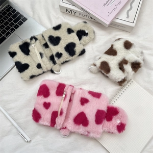 Detailed view of three cute plush storage bags with heart patterns in pink and brown