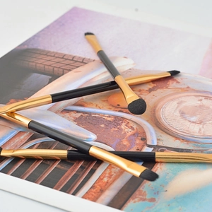 Dual-ended eyeshadow sponge and brush set with black handles and golden ferrules