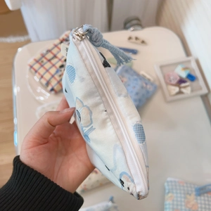 Detail of blue floral cotton mini pouch showing zip closure and soft fabric texture