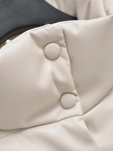 Detailed macro view of off-white leather jacket featuring matching covered buttons
