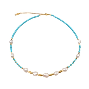 Handmade turquoise bead and freshwater pearl necklace with gold accents on white background
