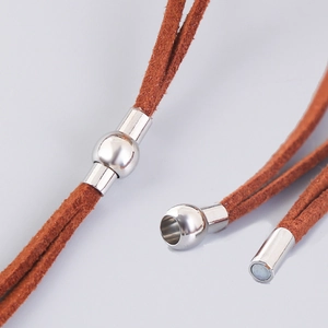 Close-up of brown suede leather necklace cord with silver magnetic clasp closure