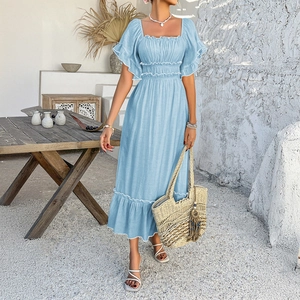 Blue bohemian ruffled mini dress styled for summer vacation with a crossbody straw bag