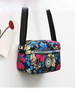 Close-up of floral print oxford nylon crossbody bag with multi-layer metal zippers
