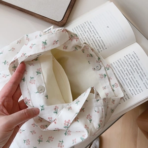 Detail of floral cotton handbag interior with magnetic snap closure and inner pocket