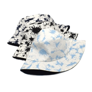 Detailed view of tie-dye canvas bucket hats in blue and black splash patterns