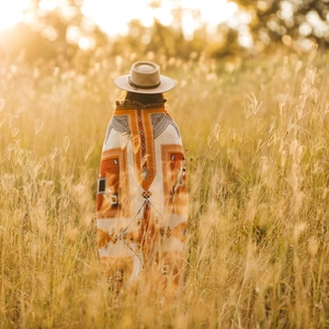 Detail of bohemian knit outdoor blanket with geometric patterns and fringe tassels