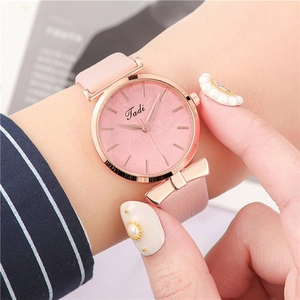 Close-up of pink leather watch with rose gold case and radiant feather pattern dial