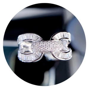 Macro shot of silver U-shaped interlocking ring with rectangle zircon inlay and shiny metal