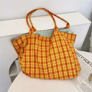 Detail of checkered tote bag with bright yellow plaid pattern and mint green lining