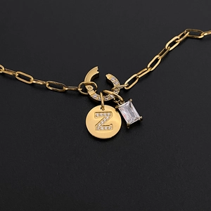 Close-up of gold paperclip chain with crystal letter Z and emerald cut zircon pendants