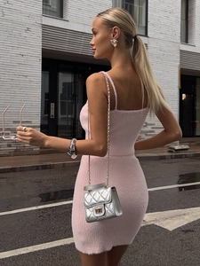 Detailed view of pink knitted plush bodycon dress with chic silver chain handbag accessory