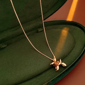Golden puppy necklace with tiger eye stone in a premium green velvet jewelry box