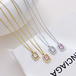 Minimalist square zircon pendant necklace in gold and silver finish on white textured box
