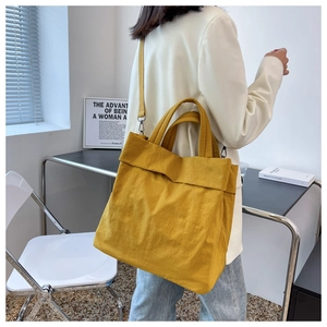 Close-up of ginger yellow nylon tote bag styled with a white blazer for a casual look