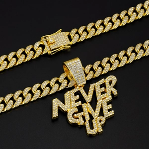 Macro view of gold plated cuban link chains with rhinestone Never Give Up pendant