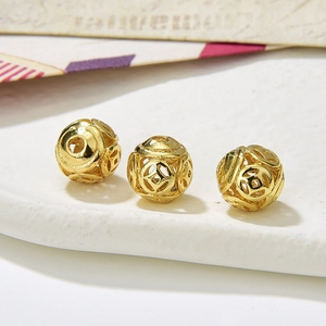 Macro shot of three hollow gold alloy beads with traditional Chinese coin patterns for DIY
