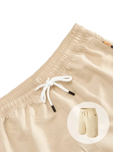 Detail of khaki quick-dry shorts with elastic waistband, white drawstrings and zipper pocket