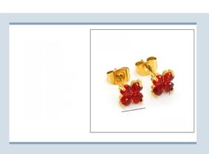 Détail de boucle d'oreille trèfle avec zircons rouges en cœur et placage en or 18 carats