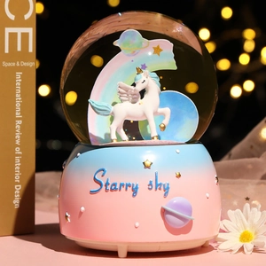 Detail of unicorn crystal ball music box with starry sky gradient base and dreamy bokeh