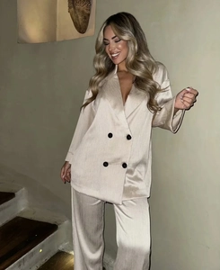 Détail de l'ensemble tailleur en satin champagne avec blazer croisé et pantalon fluide
