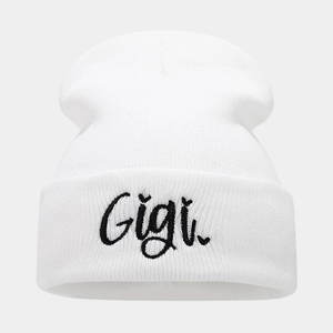 Detailed view of the black Gigi embroidery on a white folded cuff knit beanie