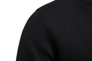 Macro detail of high-quality shoulder stitching and knitted texture on a black men's sweater