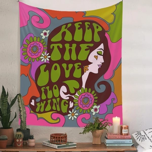 Detailed view of a psychedelic tapestry on a white wall with 'Keep the Love Flowing' text