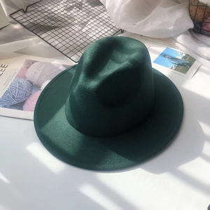 Detailed view of a dark green wool fedora hat with a classic crown and flat brim