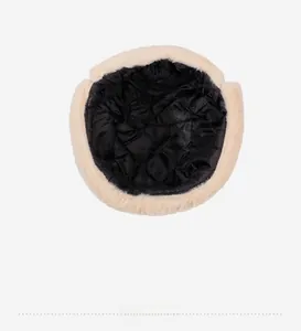 Detail view of winter trapper hat with black quilted lining and beige faux fur trim