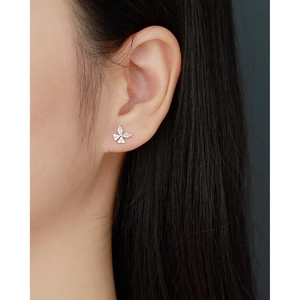 Close-up of a silver butterfly stud earring with sparkling cubic zirconia on an ear