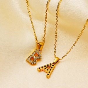 Close-up of gold 18K plated stainless steel initial necklaces with zircon inlay