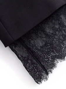 Close-up of the delicate black lace hem on the elegant suit dress for women