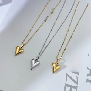 Detailed view of polished heart pendant necklaces in gold and silver finishes