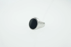 Close-up of polished silver titanium ring featuring a large oval black onyx stone inlay