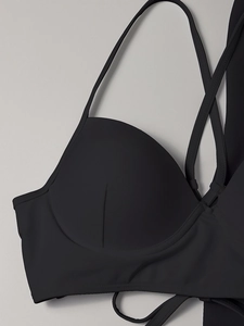 Détail du haut de bikini noir avec bonnets à armatures et bretelles croisées