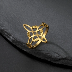 Detailed close-up of golden Celtic knot ring on a natural dark rock background