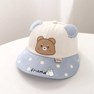 Détail d'un chapeau de soleil bébé avec oreilles 3D, broderie ours et bord à pois