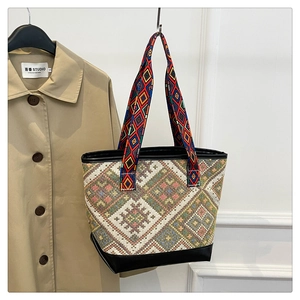 Detail of ethnic tote bag showing geometric embroidery and colorful woven straps