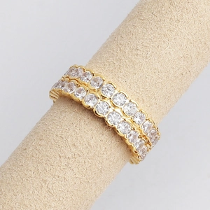Detailed macro view of a gold double-row eternity ring with white cubic zirconia stones