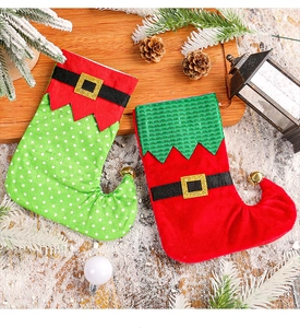 Chaussettes de Noël en forme de bottes d'elfe avec clochettes sur un plateau festif