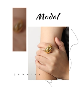 Detailed view of water-drop shaped gold ring with sparkling colorful rhinestones