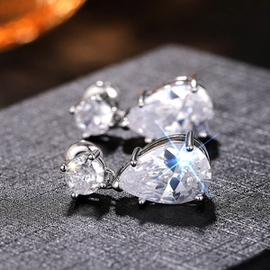 Vue macro de boucles d'oreilles argentées en forme de goutte avec des pierres brillantes