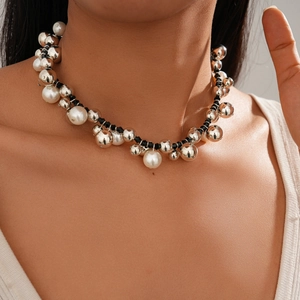 Close-up of oversized silver metal beads and faux pearls on a black woven necklace cord