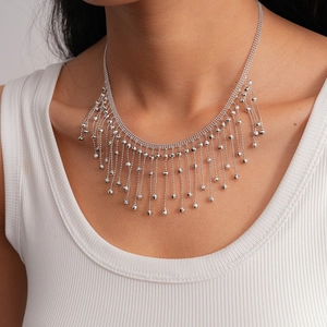 Close-up of silver multilayer tassel necklace with faceted metal beads on model