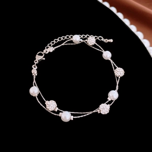 Detail of double-layer silver bracelet with white pearls and pave crystal spheres on black velvet