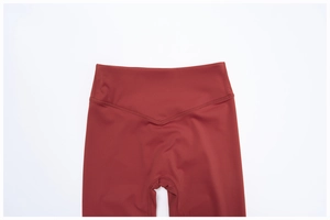 Détail de la taille haute en V du legging de yoga rouge rouille avec coutures plates